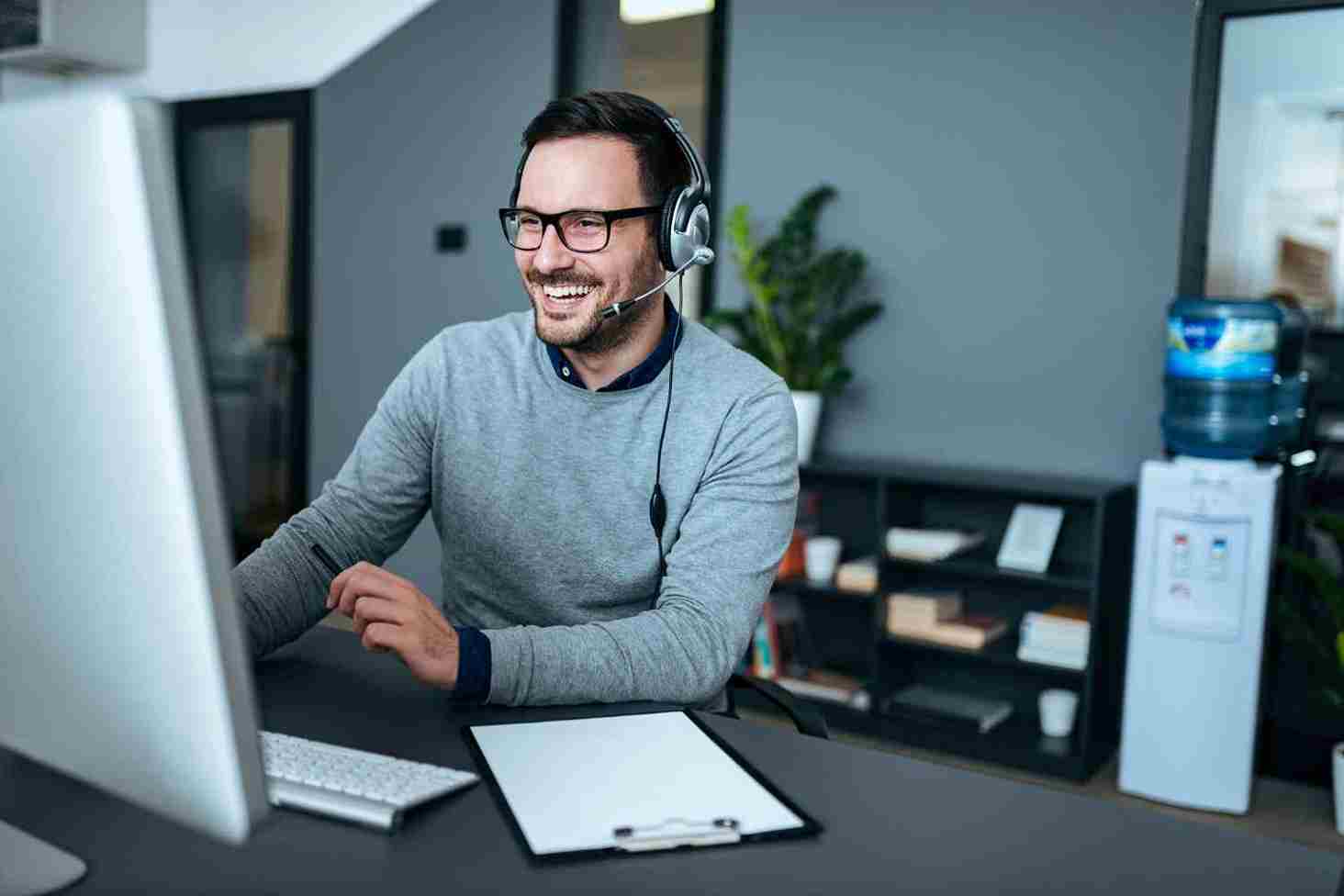 Homem sorrindo olhando para o computador
